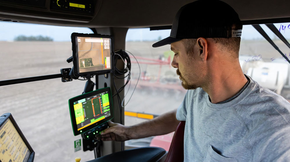 Farmer in the cab of a tractor.
