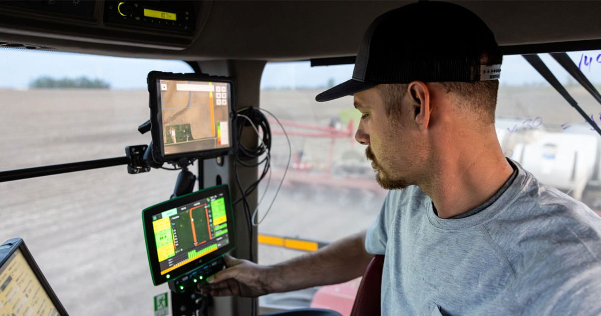 Farmer in the cab of a tractor.