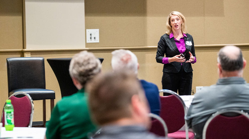Woman speaking to owners forum attendees