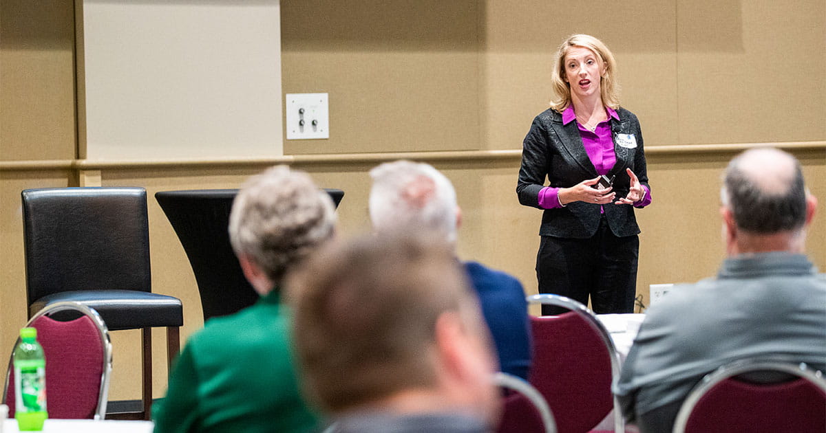 Woman speaking to owners forum attendees