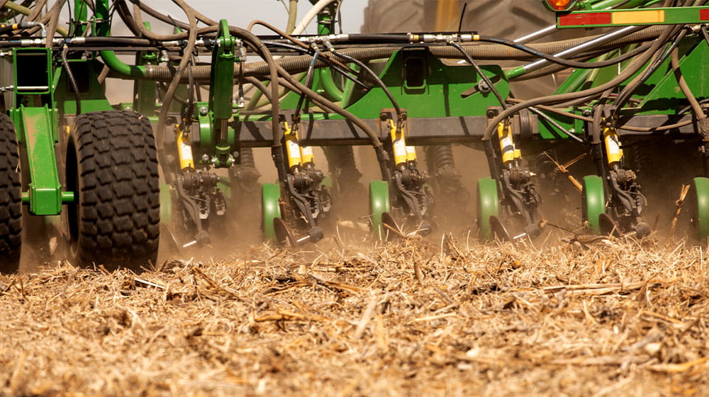 Tractor pulling planter through tilled field