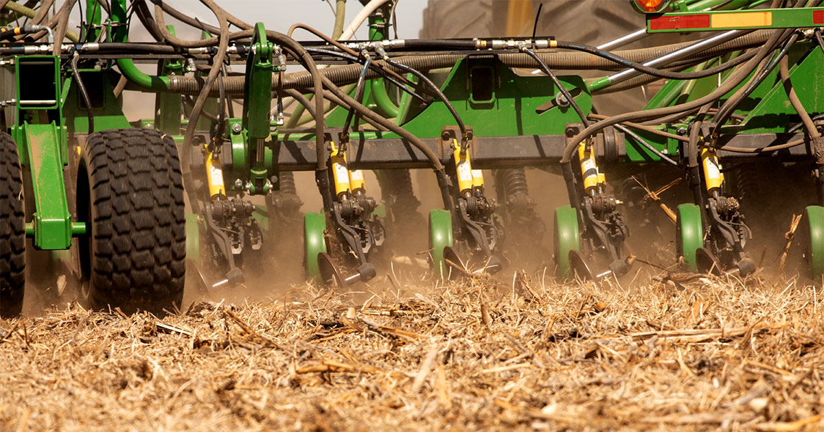 Tractor pulling planter through tilled field