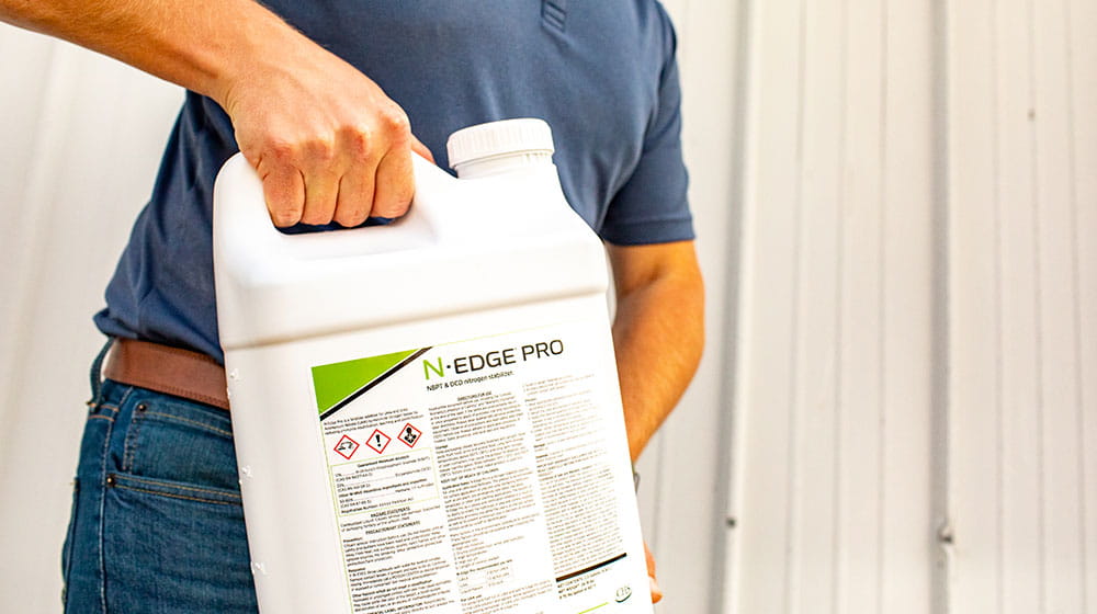 Man holding a jug of farm chemicals.