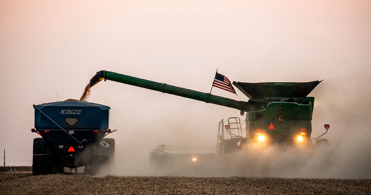 Combine harvesting field at dusk 