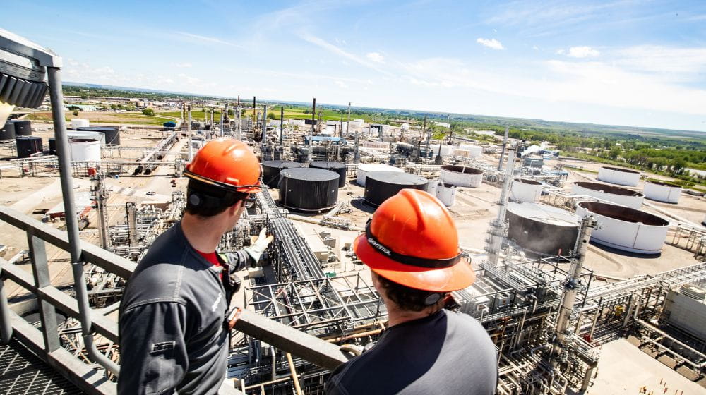 Two men overlooking a refinery 